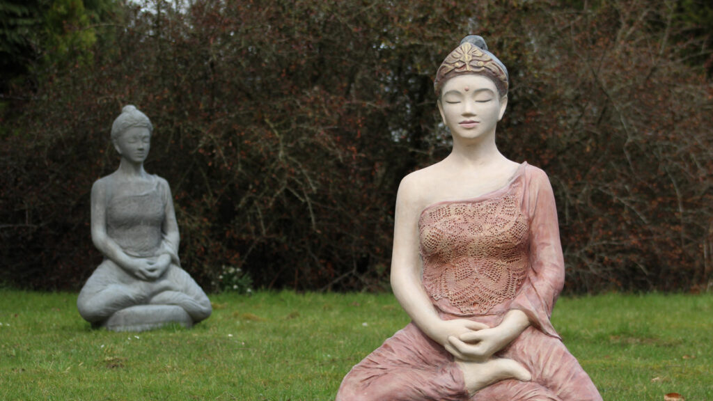 Große weibliche Buddha-Statue / Tara-Figur auf Wiese